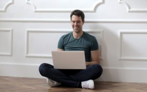 image of man in green crew neck t-shirt using laptop